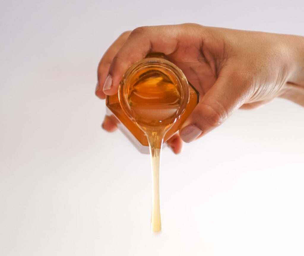 honey health facts - honey being poured out of jar